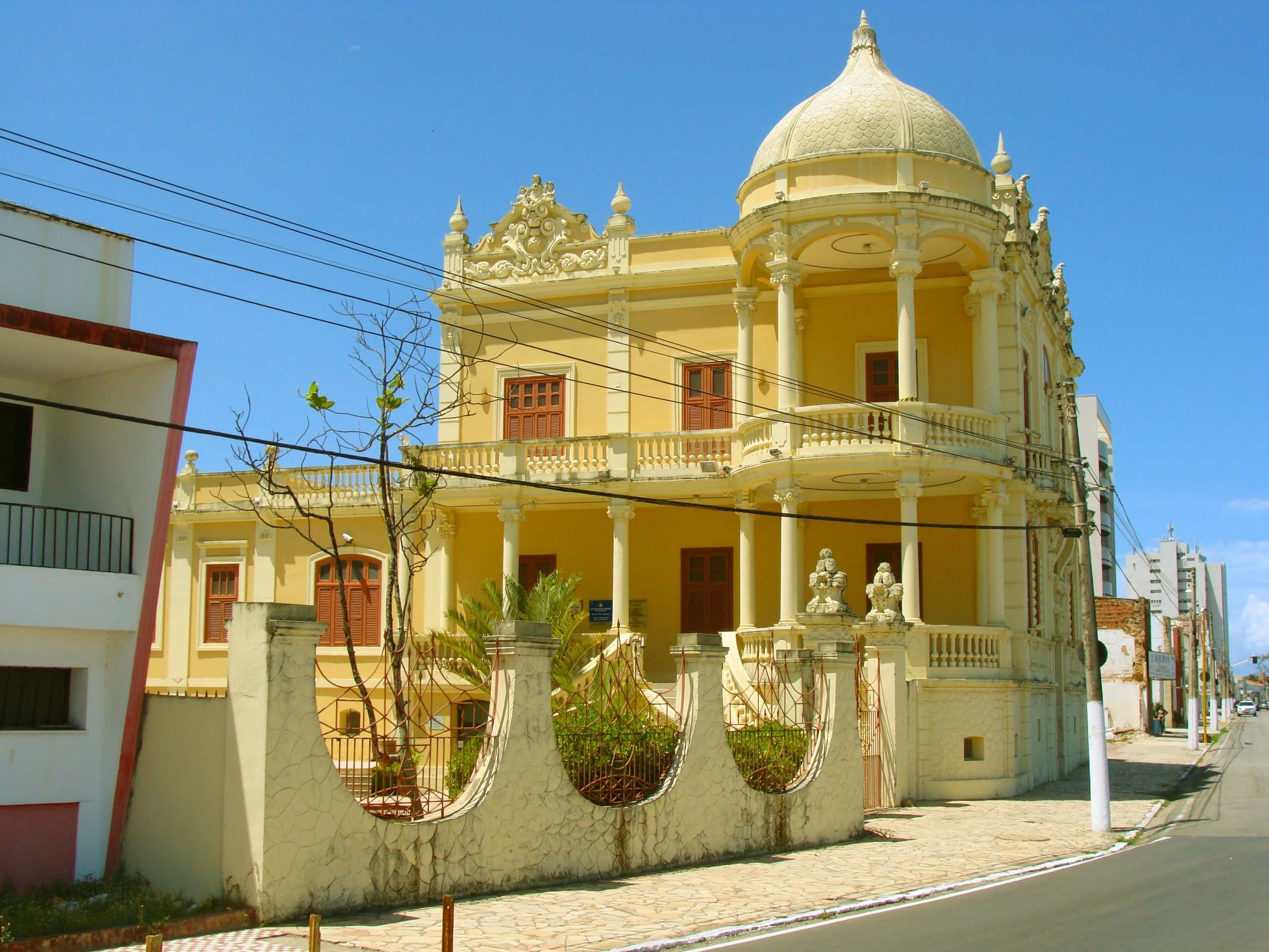 Palacete amarelo de estilo eclético onde funciona o Museu Théo Brandão, na orla da Avenida da Paz